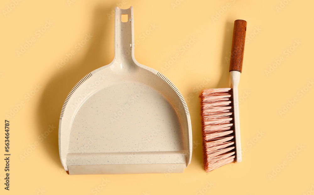 Plastic dustpan with cleaning brush on color background