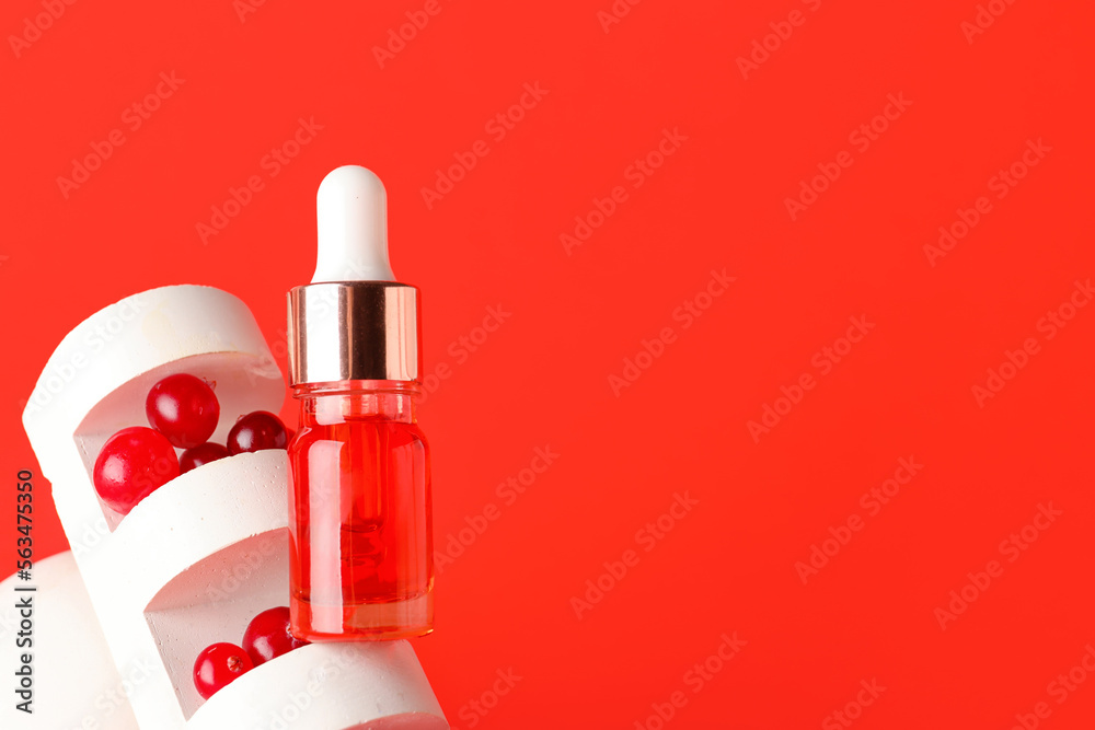 Bottle of serum, cranberry and decor on color background