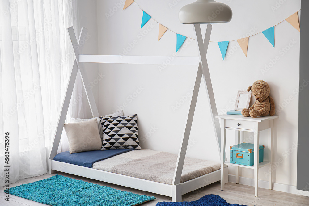 Stylish interior of childrens room with baby bed