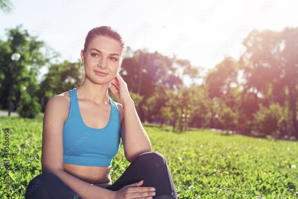 Beautiful smiling girl in sportswear relax in park