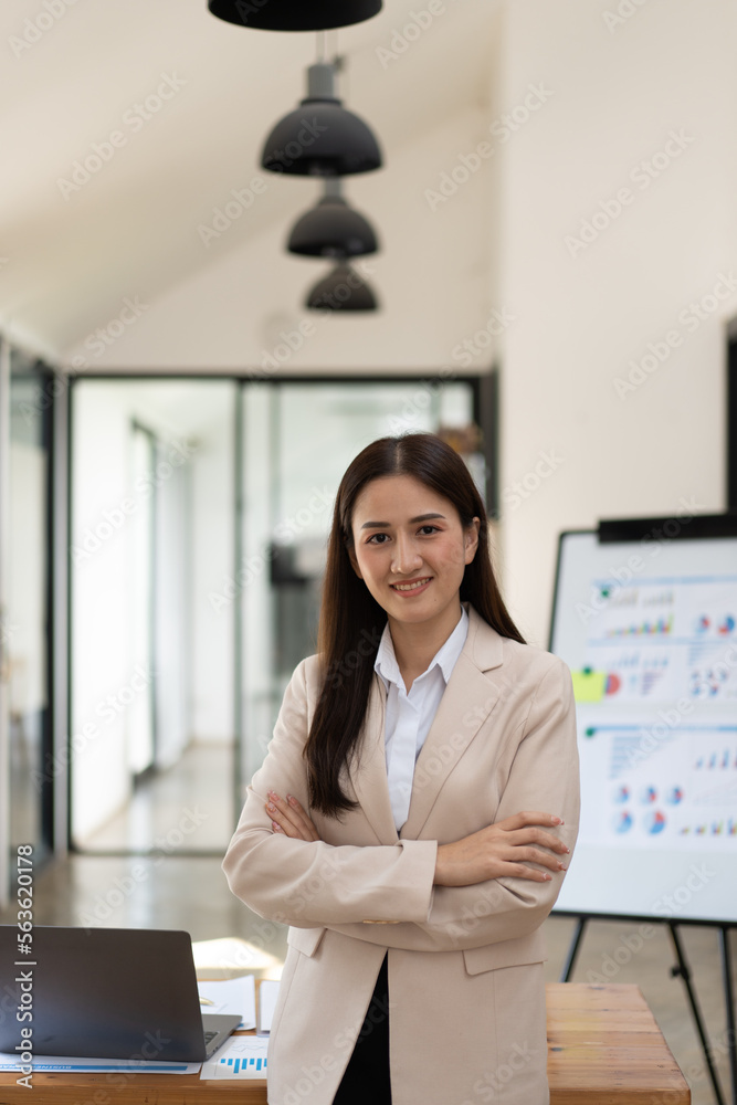 Confident Latin business leader portrait, Young businesswoman in suit posing with arms folded, looki