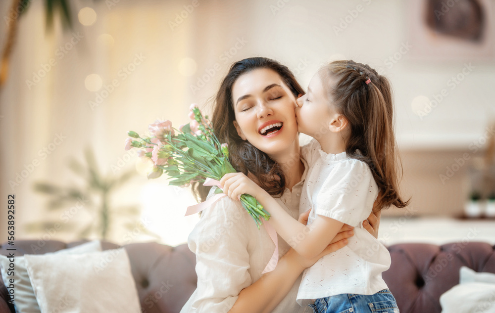 Daughter giving mother bouquet of flowers.