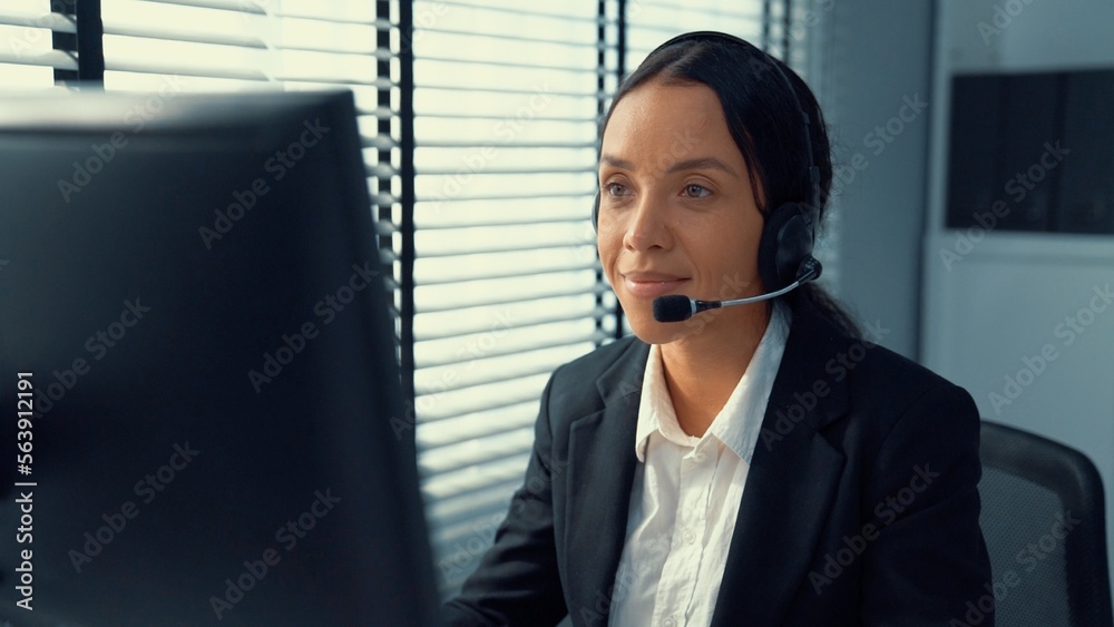 Competent female operator working on computer and talking with clients. Concept relevant to both cal