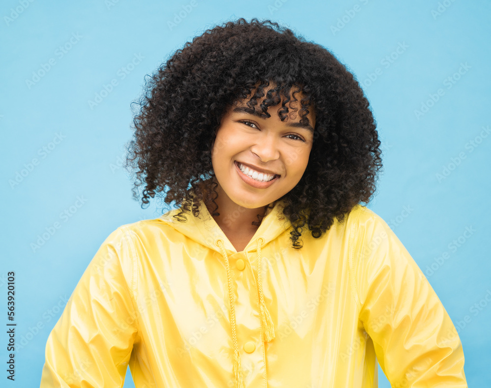 Woman, smile and happy in portrait with fashion for winter, rain coat and beauty isolated on blue ba