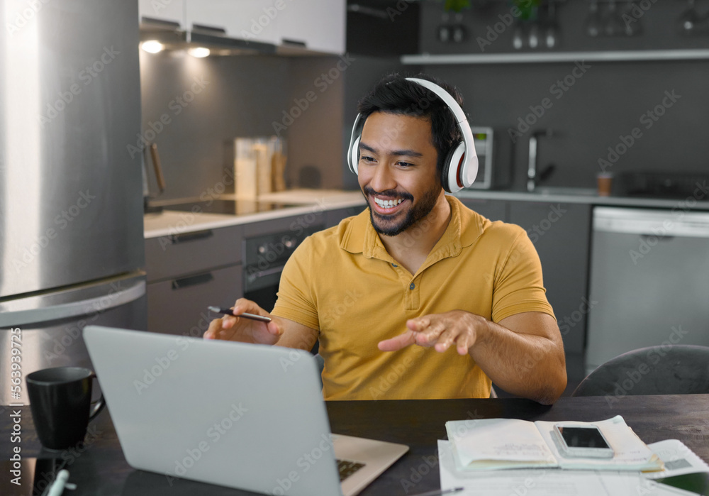 Happy man, headphones and webinar or music on laptop in home office while talking online. Entreprene