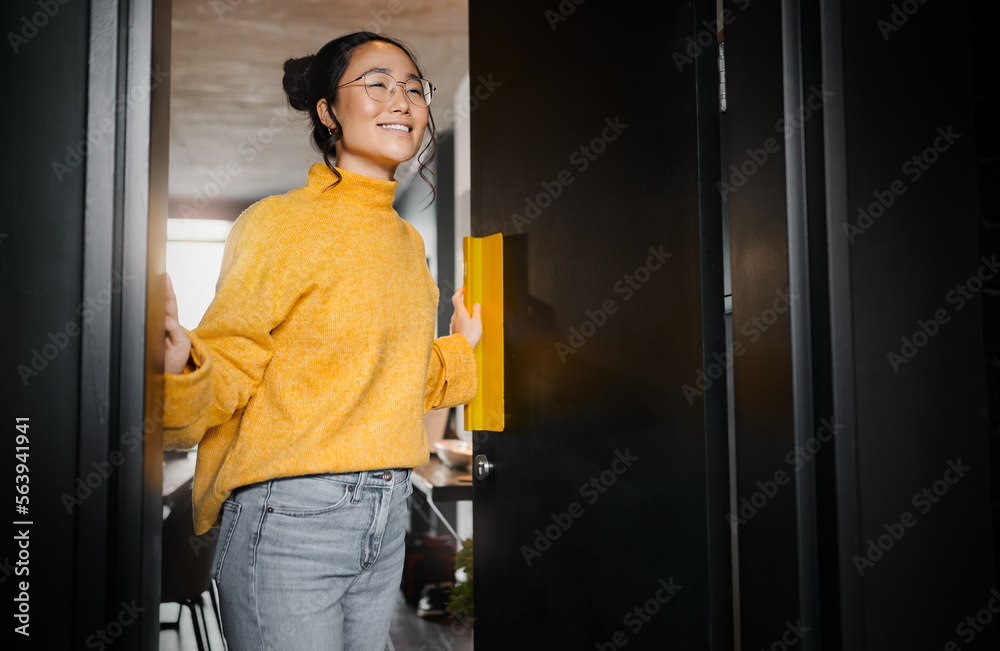 Entrance, creative and Asian woman opening a door to an office at a graphic design startup company. 