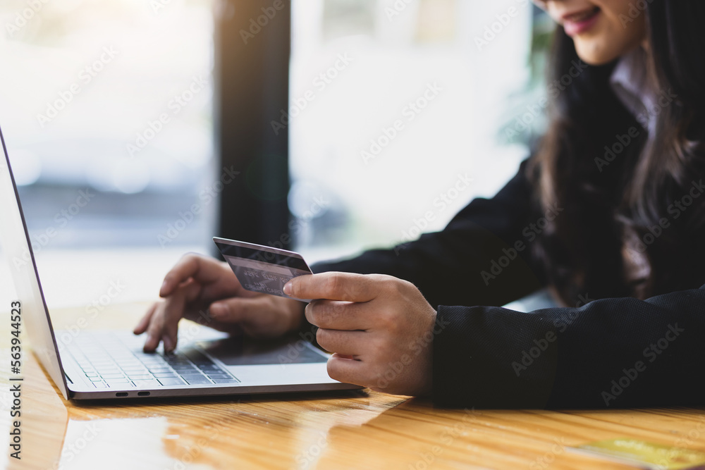 Woman holding credit card and using laptop. Online payment and online  shopping concept.