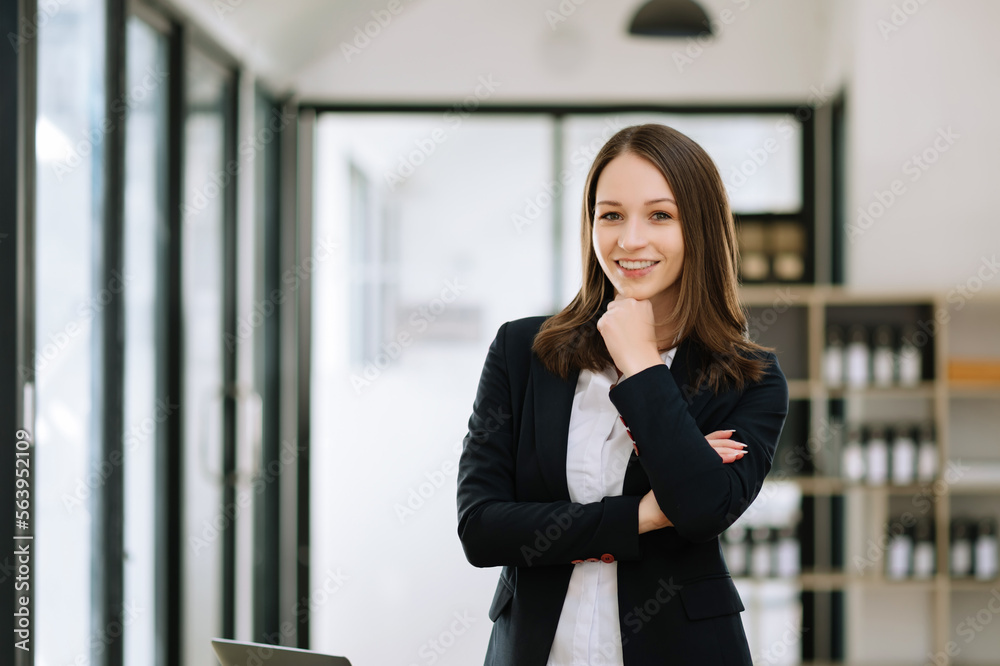 Confident female entrepreneur looking at the camera while standing. Young businesswoman standing in 