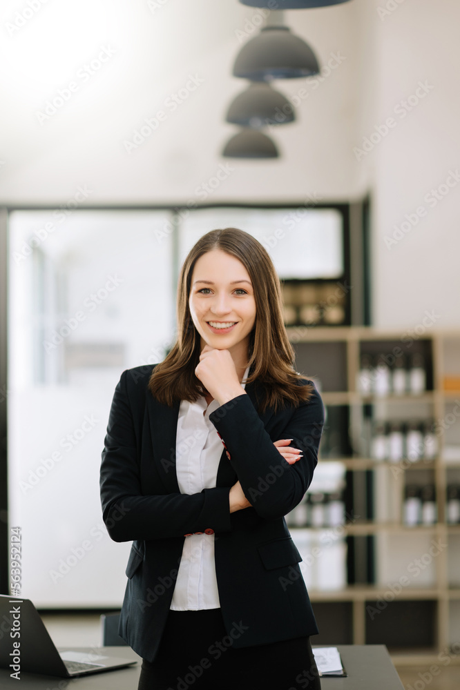 Confident female entrepreneur looking at the camera while standing. Young businesswoman standing in 