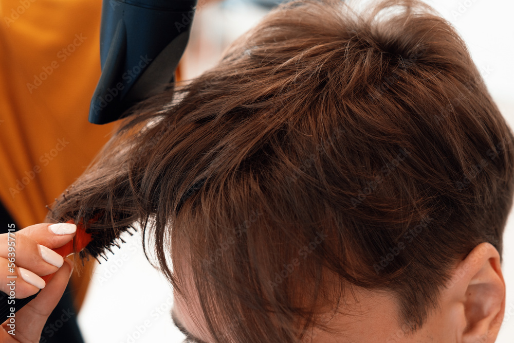 Closeup asian female barber making haircut for male customer with male hairstyle in qualified barber