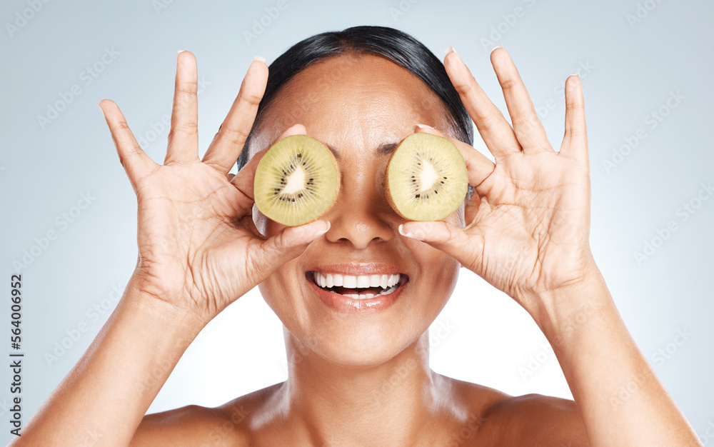 Skincare, beauty and woman with kiwi on eyes for vitamin c facial detox and smile on studio backgrou