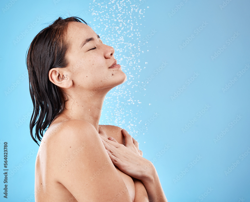 Asian woman in shower, water on face and skincare beauty with healthy wet hair on blue background. W