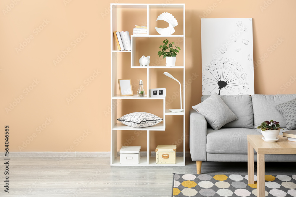 Interior of stylish living room with grey sofa, table and shelving unit