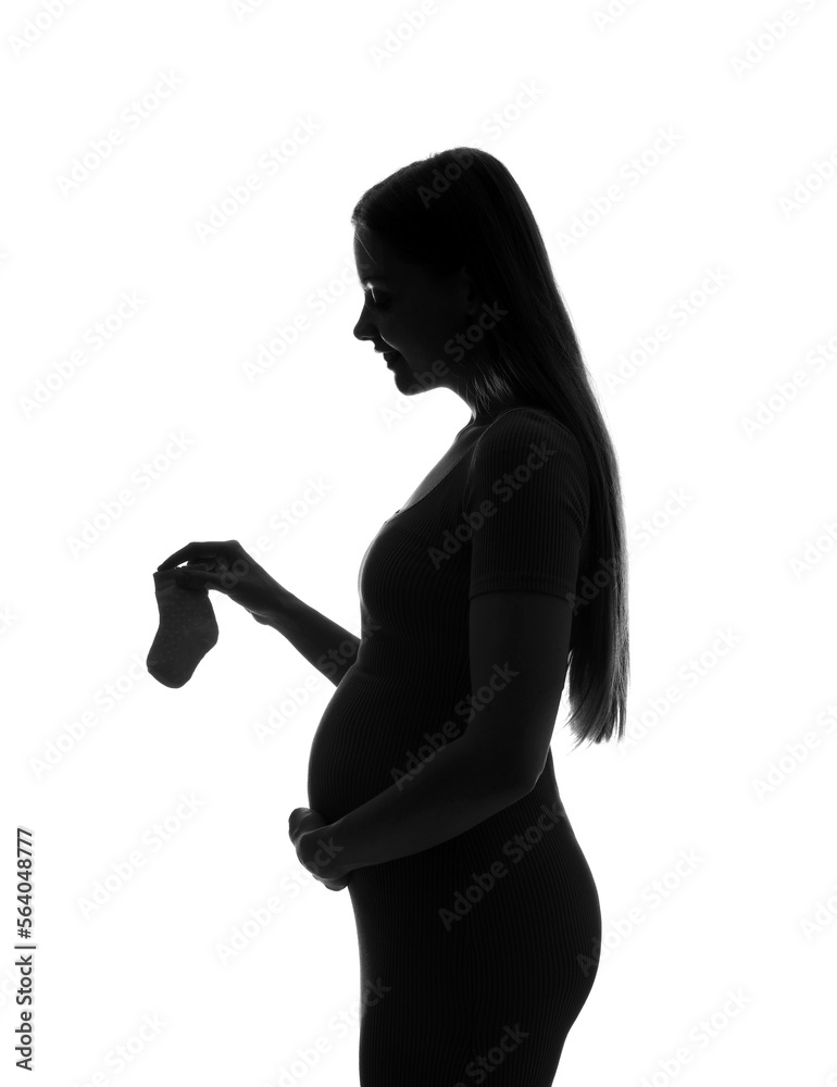 Silhouette of young pregnant woman with baby socks on white background