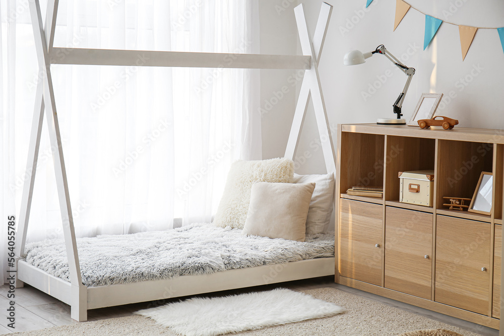 Stylish interior of childrens room with baby bed