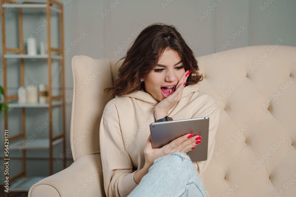 Freelancer young girl search web online looking tablet expression amazed shock .