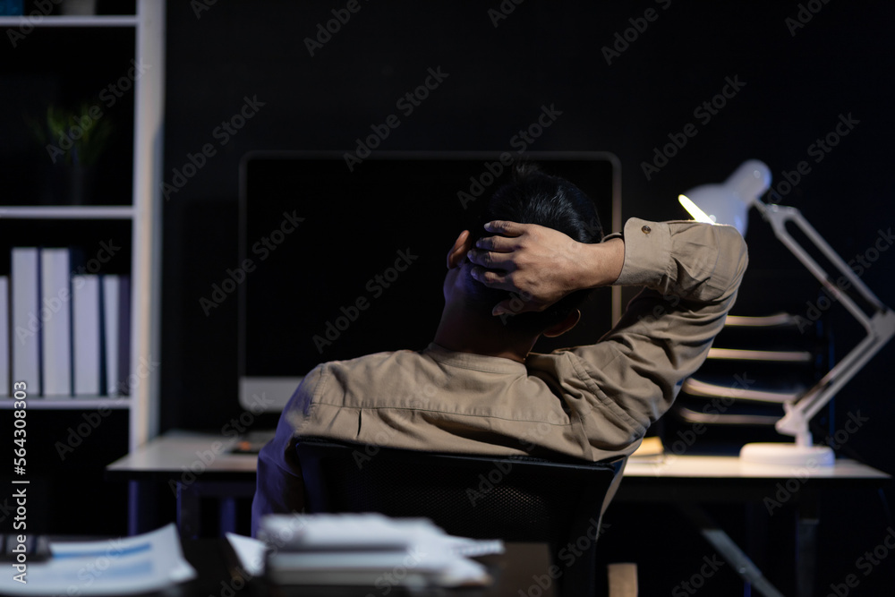 Responsible and determined businessman working overtime on computer in the night office.