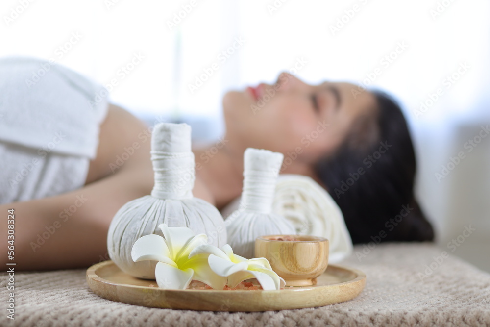 Beautiful young woman in spa salon. Beautiful spa composition on massage table in wellness center on