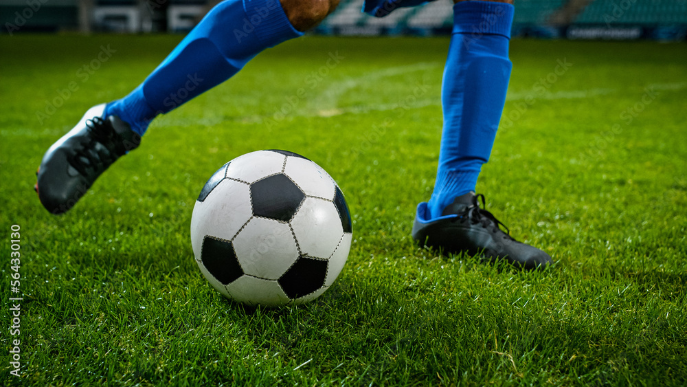 Close-up of a Leg in a Boot Kicking Football Ball. Professional Soccer Player Hits Ball with Fierce 