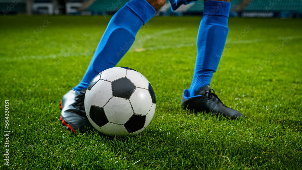 Close-up of a Leg in a Boot Kicking Football Ball. Professional Soccer Player Hits with Fierce Power