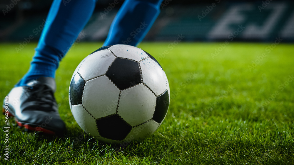 Close-up of a Leg in a Boot Kicking Football Ball. Professional Soccer Player Hits Ball with Fierce 