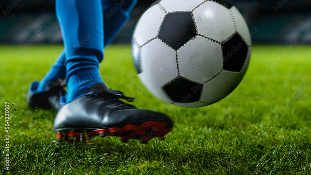 Close-up of a Leg in a Boot Kicking Football Ball. Professional Soccer Player Hits Ball with Fierce 