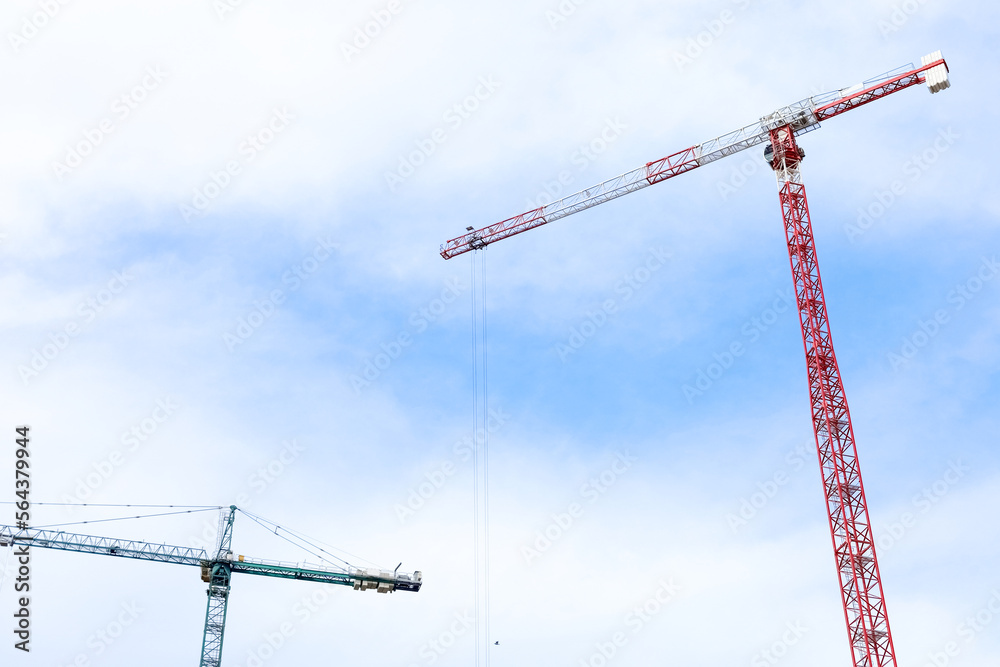 Construction cranes against blue sky