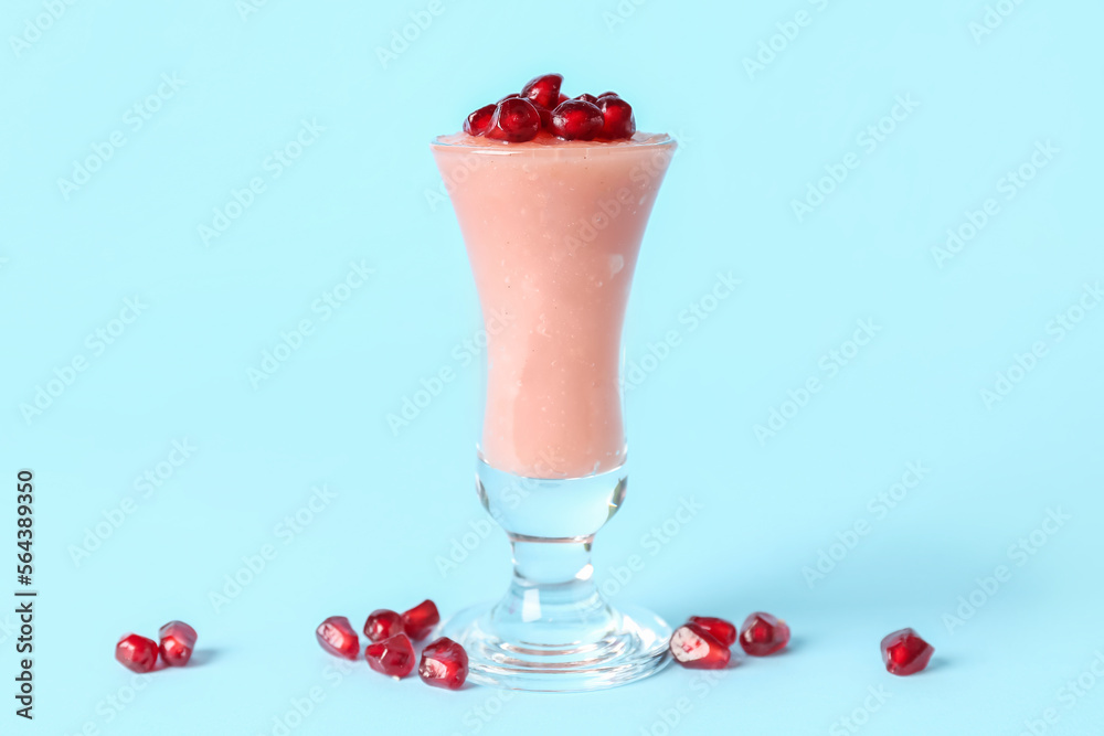 Shot of delicious pudding with pomegranate seeds on blue background