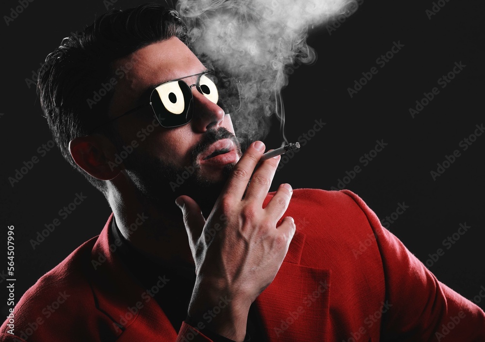 Fashion, smoke and face with a man model in studio on a dark background wearing a suit for style. Sm