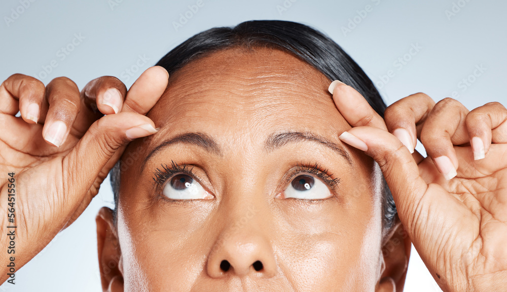 Face, skincare and woman squeeze wrinkles in studio isolated on a gray background. Makeup cosmetics,