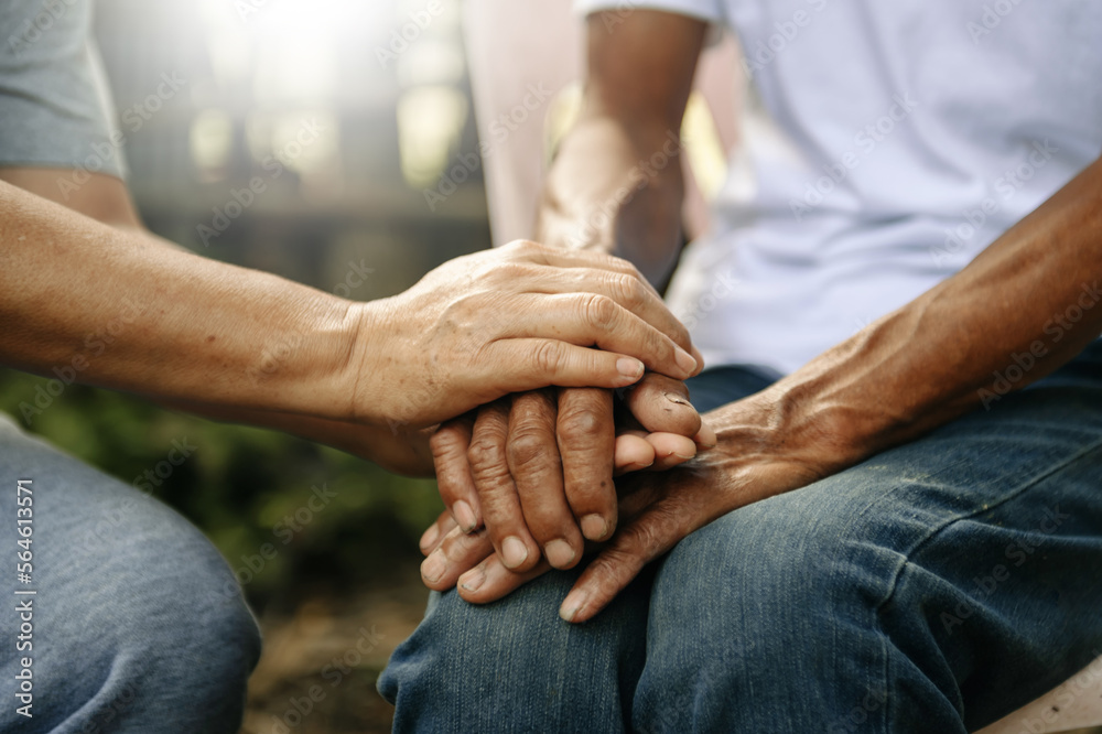 Hands of the old man and a woman hand