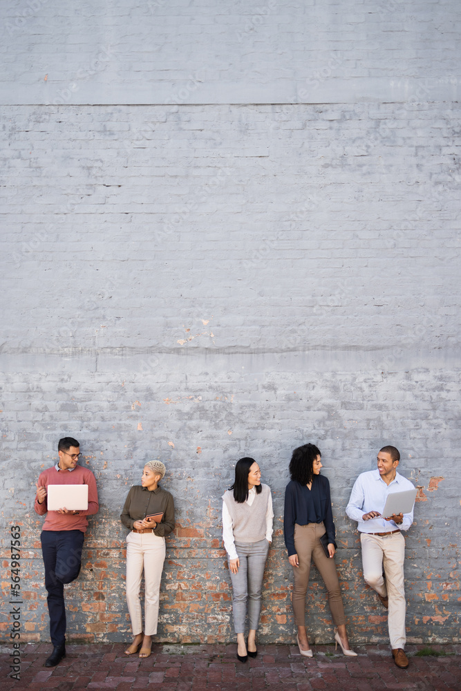 Diversity, business people talking and standing outdoor with technology for wall mockup, happy conve