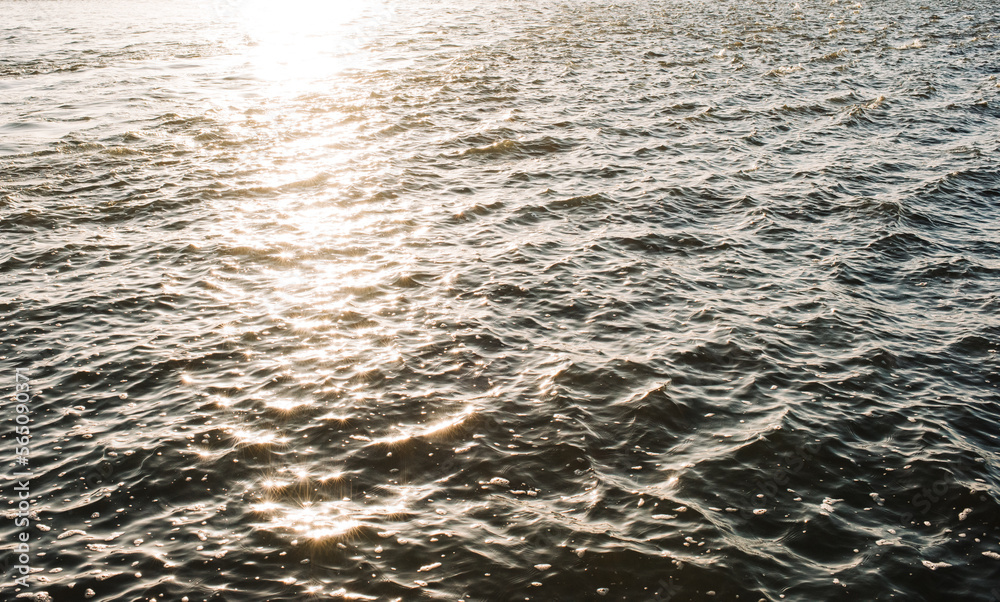 Sea waves glistening in the golden sun at sunset