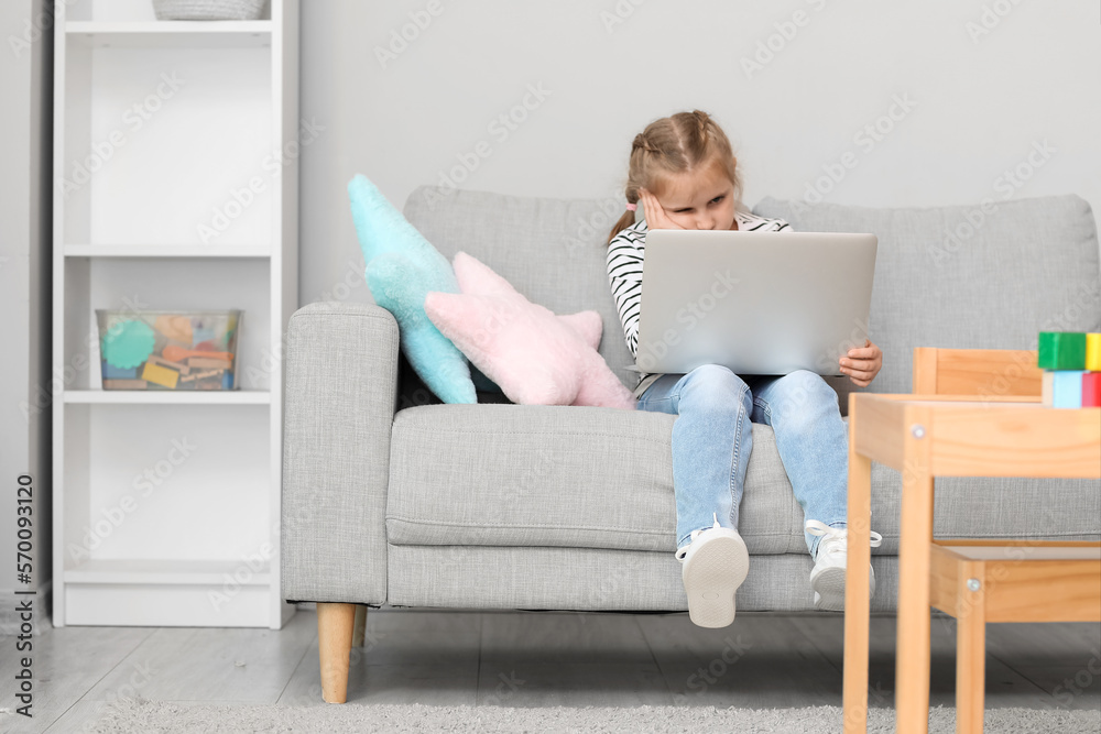 Upset little girl video chatting with psychologist on laptop at home