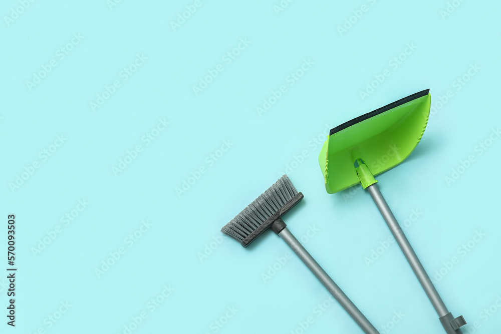 Broom with plastic dustpan on color background