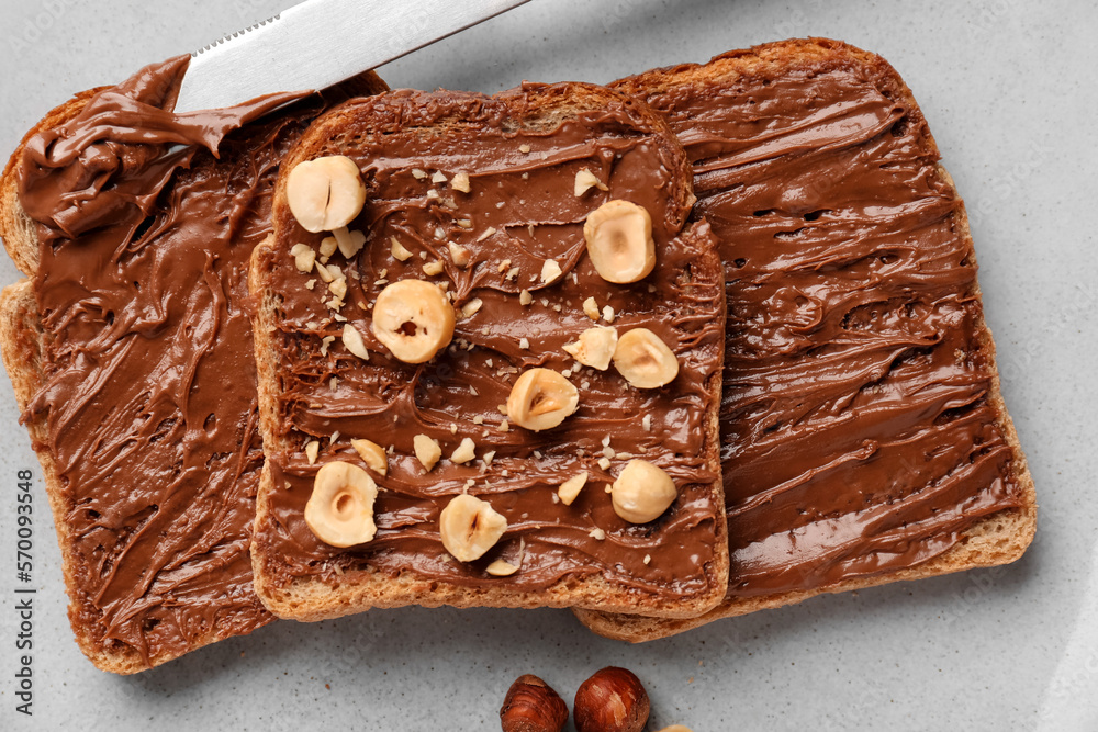 Plate of tasty toasts with hazelnut butter and nuts, closeup