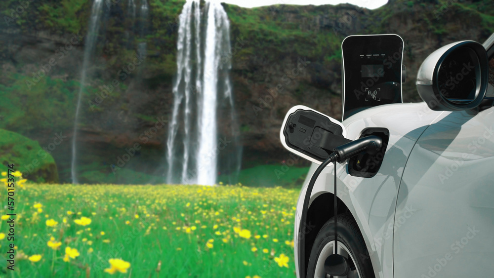 Electric car charging energy from charging station in the natural scenery, waterfall and stream back