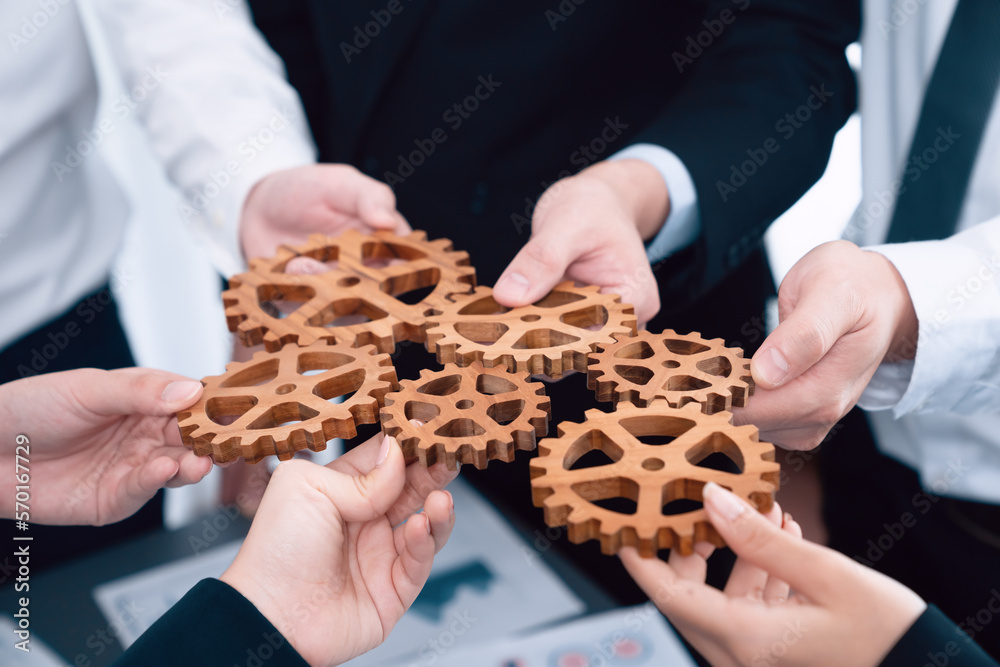 Closeup top view businesspeople hand holding gear and join together over meeting table with financia