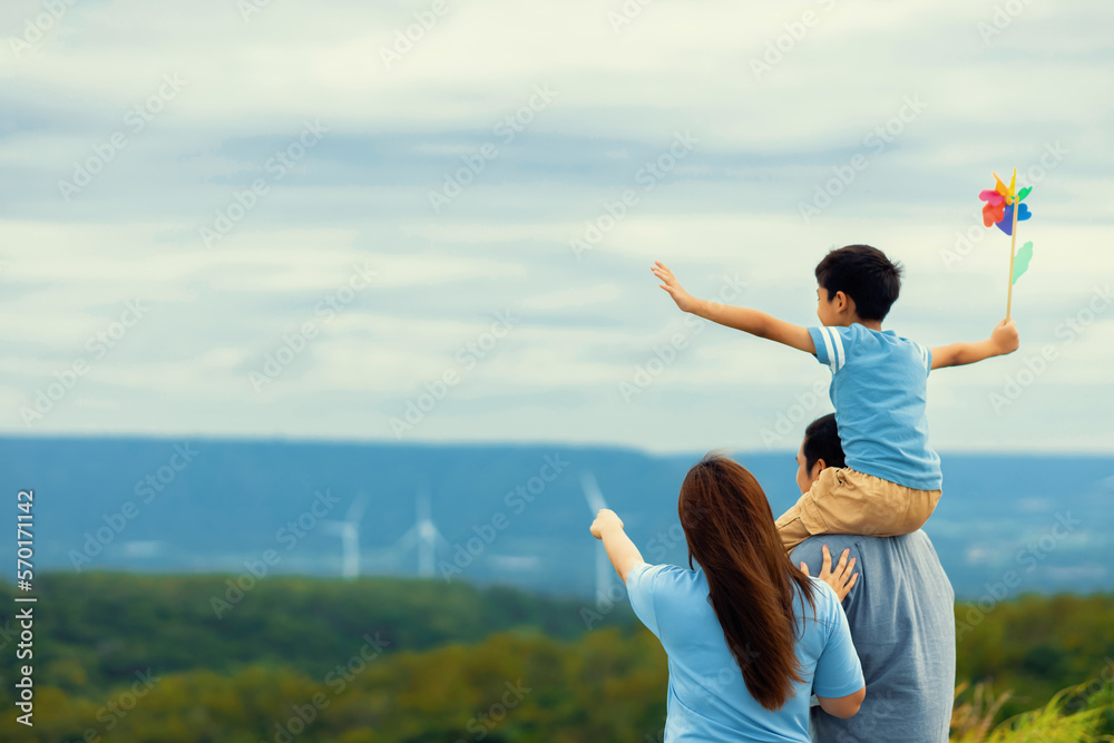 Progressive happy family enjoying their time at wind farm for green energy production concept. Wind 