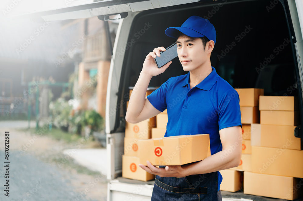 Happy delivery man standing with arms crossed near van outside the warehouse. This is a freight tran