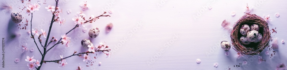 Easter eggs,nest and spring blooming branches on pink background.