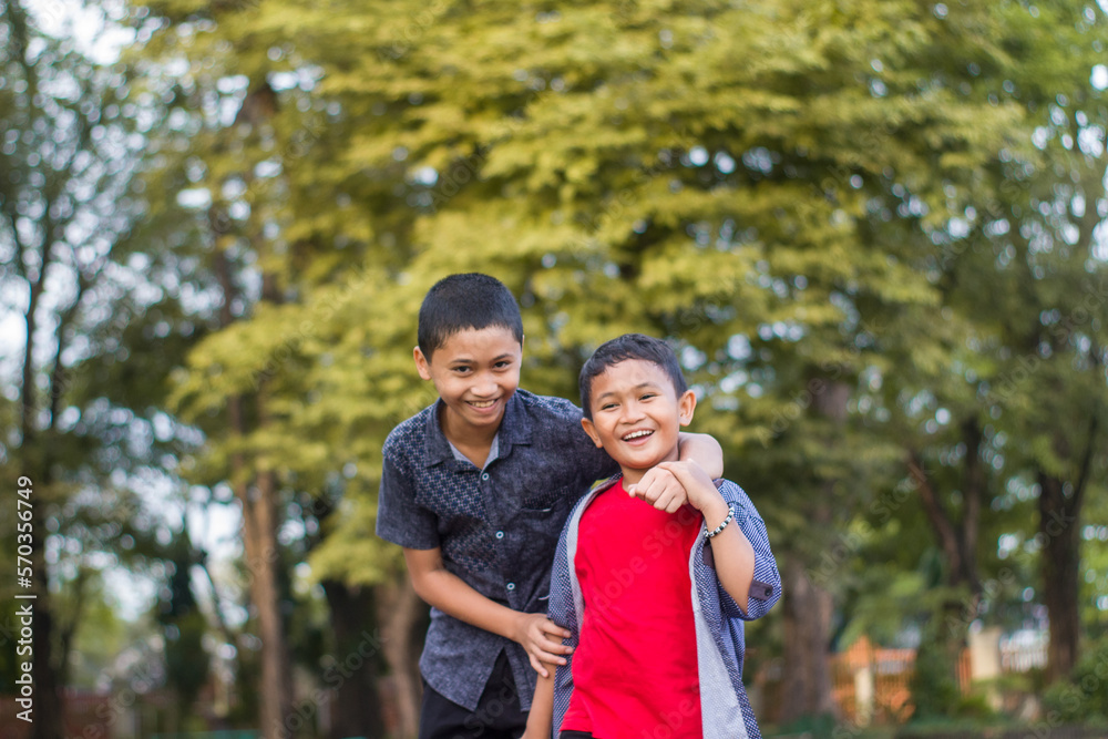 Two boys joking and playing in the park