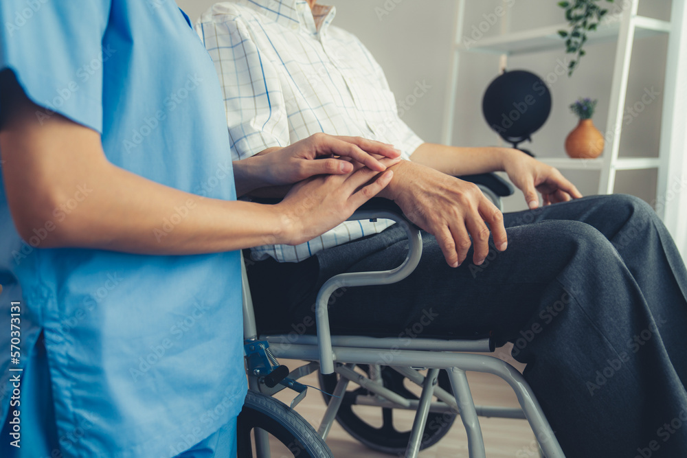 Caring nurse and a contented senior man in a wheel chair at home, nursing house. Medical for elderly