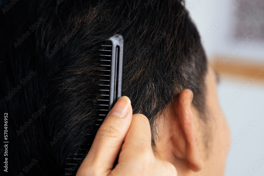 Closeup asian female barber making haircut for male customer with male hairstyle in qualified barber