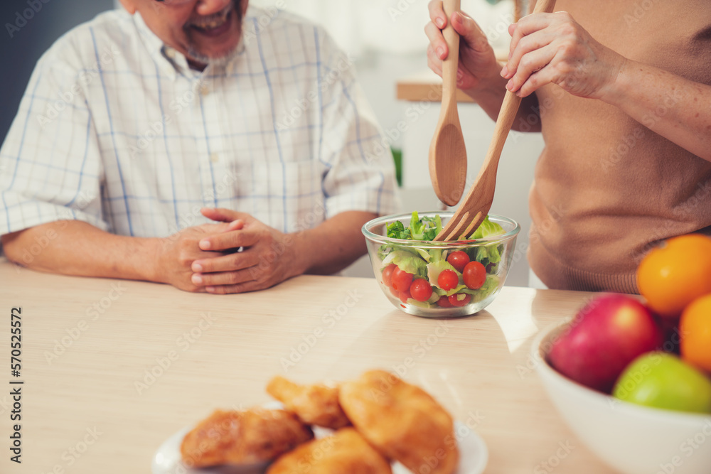 Contented senior couples who are happy to cook together with bread veggies and fruit in their kitche