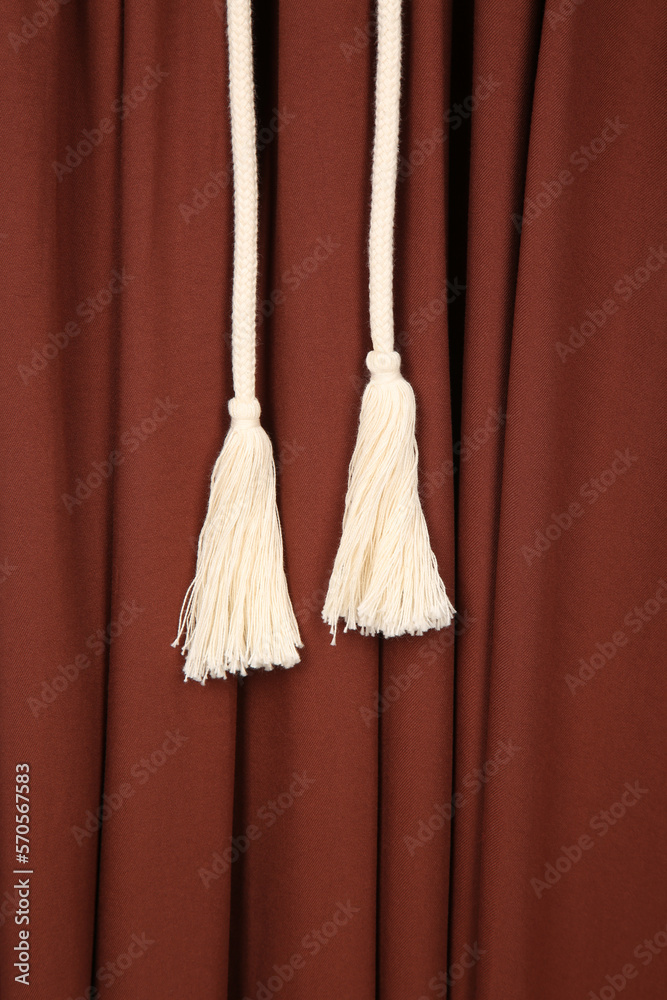 Tassels on laces on a background of brown fabric