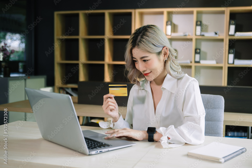 Woman using smart phone for mobile payments online shopping,omni channel,sitting on table,virtual ic