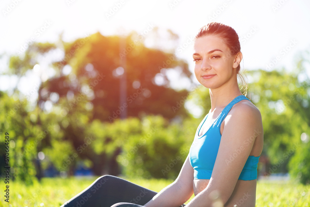 Beautiful smiling girl in activewear relax in park