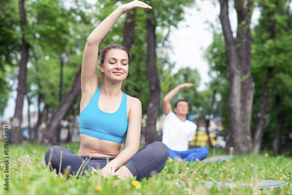 Girl meditates in lotus pose on green grass