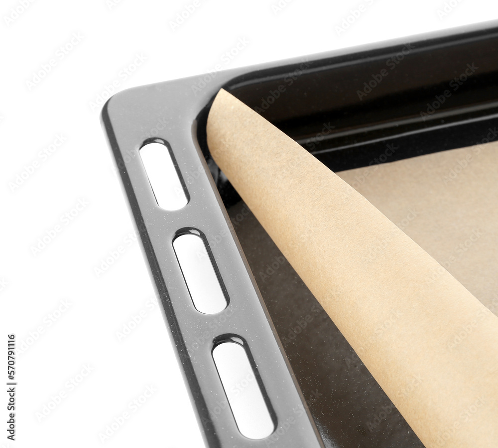 Baking sheet with paper on white background, closeup